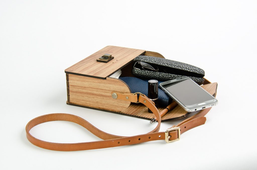 wooden handbag showing capacity to contain